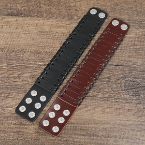 Detail of woven leather texture and silver snap buttons on punk bracelets in black and brown
