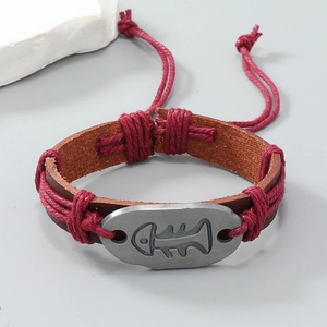 Detail of vintage braided leather bracelet with fishbone alloy charm and adjustable red cord