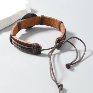 Close-up of vintage brown leather bracelet with woven rope and adjustable drawstring closure