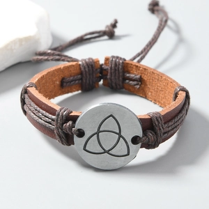 Detail view of brown leather punk bracelet featuring a Celtic Triquetra metal charm