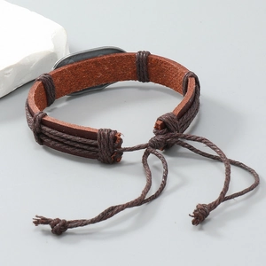 Detail of hand-woven fishbone leather bracelet with silver-tone metal plate and drawstring