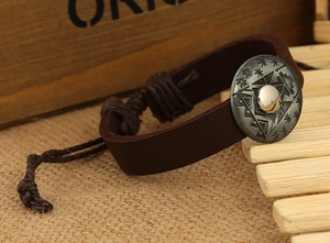 Macro view of vintage brown leather bracelet with ethnic metal buckle and woven cord tie