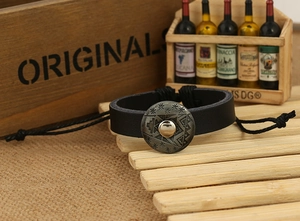 Detail of vintage black braided leather punk bracelet with star pattern metal buckle
