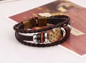 Close-up of vintage multi-layer leather bracelet with bronze star pendant and metal rings