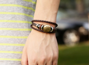 Detailed view of multilayer leather bracelet with bronze star charm on wrist