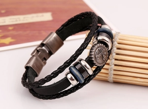 Close-up of a multi-layer punk leather bracelet with a mechanical gear pendant