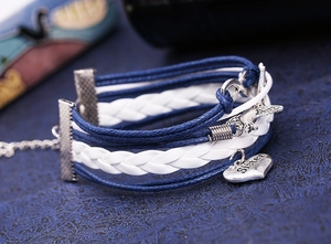 Detail of woven bracelet with infinity charm, bird wing and Sister engraved heart