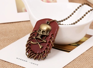Close-up of retro skull and crossbones leather pendant with bronze metal trim