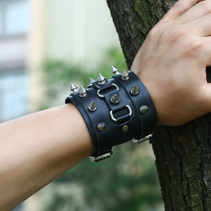 Bracelet punk en cuir noir avec clous coniques argentés et anneaux en métal au poignet