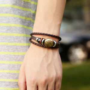 Handcrafted multilayer leather bracelet with braided cords and bronze star pendant on wrist