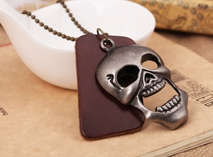 Vue détaillée du pendentif crâne vintage avec étiquette en cuir marron et chaîne à billes