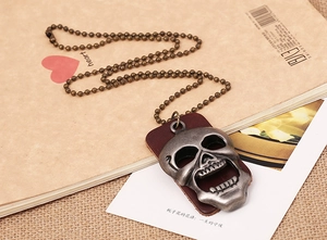 Vue détaillée du pendentif crâne vintage avec support en cuir sur chaîne à billes