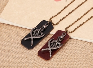 Detail of vintage leather necklace showing bronze skull and crossbones metal pendant