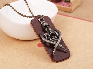 Detail of punk retro leather rectangle pendant with skull and cross swords on a metal chain