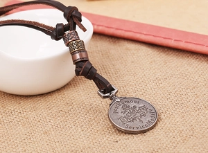 Détail du collier en cordon de cuir vintage avec pendentif médaillon en argent antique