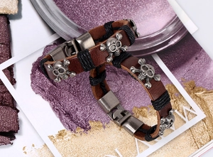Close-up of vintage brown leather bracelets with silver skull charms and metallic clasp