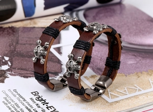 Macro detail of vintage brown leather bracelets with antique silver skull charms