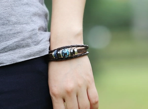 Close-up of vintage multilayer leather bracelet with blue marble bead on a wrist