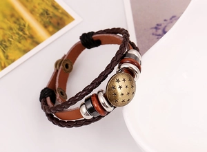 Detailed macro view of retro multi-layer leather bracelet with bronze star charm