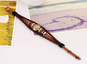 Detail of vintage multilayer leather bracelet with star disc, wooden beads and braided cords