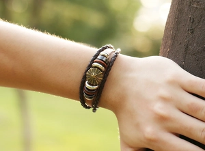 Outdoor shot of punk leather bracelet with bronze star charm and braided straps