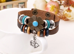 Vista dettagliata di un bracciale multistrato in pelle vintage con fiore e ancora in bronzo