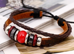 Macro detail of multi-layer leather bracelet with vintage beads and red focal stone