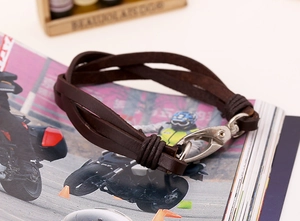 Macro detail of braided dark brown leather bracelet with silver metal lobster clasp