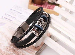 Macro shot of multi-layer braided leather bracelet with vintage floral metal charm