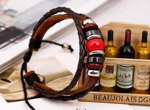 Detail of layered brown leather bracelet with red ceramic beads and adjustable cord