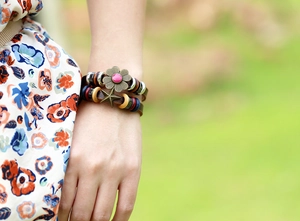 Detail of bohemian multilayer leather bracelet with bronze charms and colorful beads