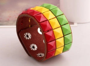 Close-up of Jamaica style leather bracelet with red, yellow, and green pyramid studs
