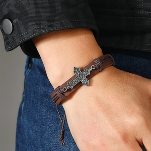 Retro brown braided leather bracelet with vintage silver cross on male wrist