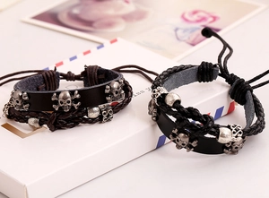 Detail of skull beads on woven leather punk bracelets in black and brown finishes