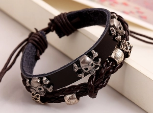 Close-up of punk style multilayer leather bracelet with silver skull charms and beads