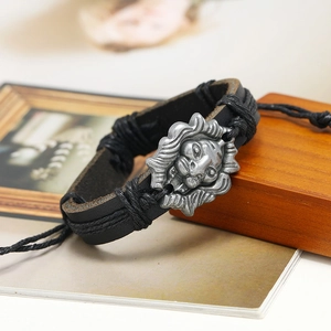 Close-up of vintage silver lion head charm on hand-woven black leather bracelet