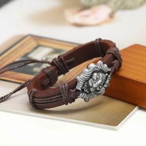 Close-up of vintage brown braided leather bracelet with antique silver lion head charm