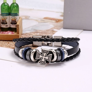 Vue détaillée d'un bracelet en cuir tressé avec pendentif en croix et fermoir en acier