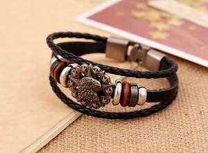 Close-up of vintage multi-layer leather bracelet with silver eagle and star metal charm
