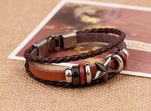 Détail d'un bracelet multicouche en cuir avec breloque étoile et perles métalliques