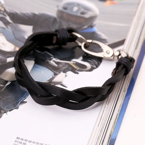Retro black braided leather bracelet with silver lobster clasp on motorcycle magazine
