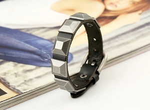 Macro view of punk leather bracelet featuring vintage silver pyramid studs and buckle