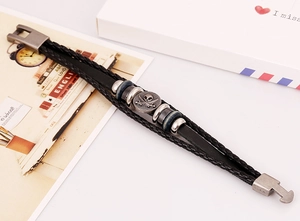 Close-up of multilayer leather bracelet with silver pirate skull and anchor charms