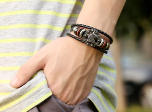 Close-up of multi-layer braided leather bracelet with vintage eagle metal badge and wood beads