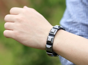 Close-up of men's punk black leather bracelet with vintage silver square pyramid rivets