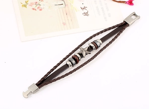 Detail view of multi-layer punk leather bracelet with vintage metal star and wood beads