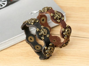 Detailed view of punk leather bracelets in black and brown with bronze skull ornaments