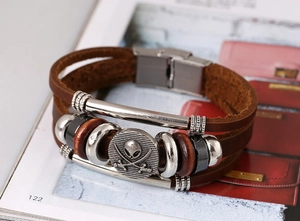 Detail of multi-layer brown leather bracelet with metal beads and skull charm