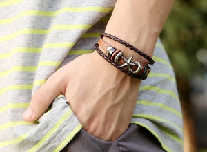 Détail d'un bracelet vintage multicouche en cuir avec breloque étoile sur un poignet