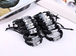 Vue à plat de douze bracelets en cuir des constellations avec breloques métalliques